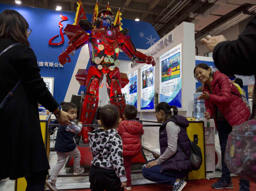 In this file photo taken Oct 21, 2016, visitors look at a Chinese made robot during the World Robot Conference in Beijing. Photo: AP