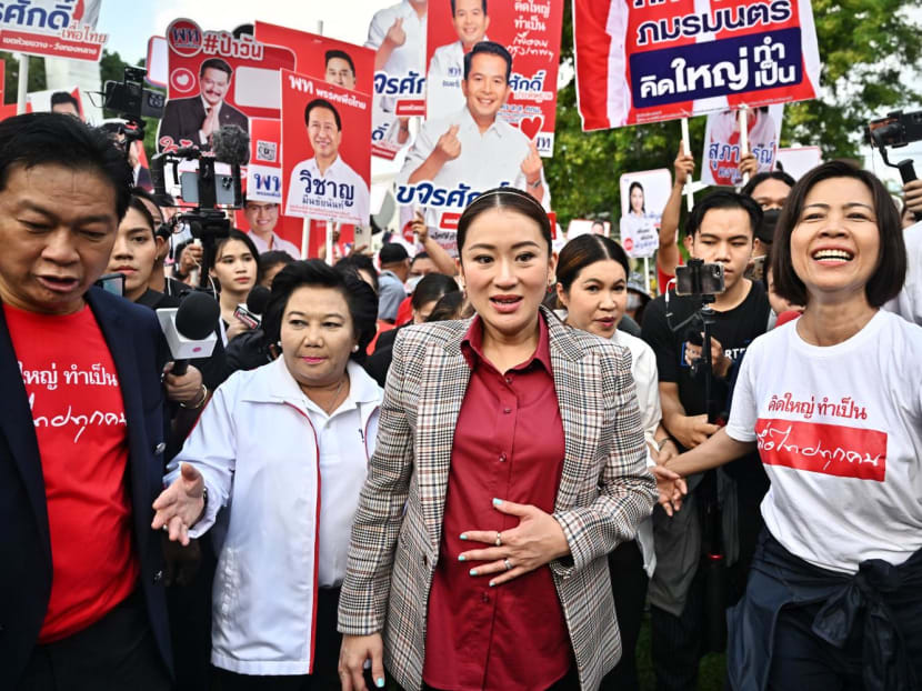 Pheu Thai Party candidate Paethongtarn Shinawatra (centre) arrives for the first day of the constituencies candidates registration for Thailand's May 14 general election, in Bangkok on April 3, 2023.