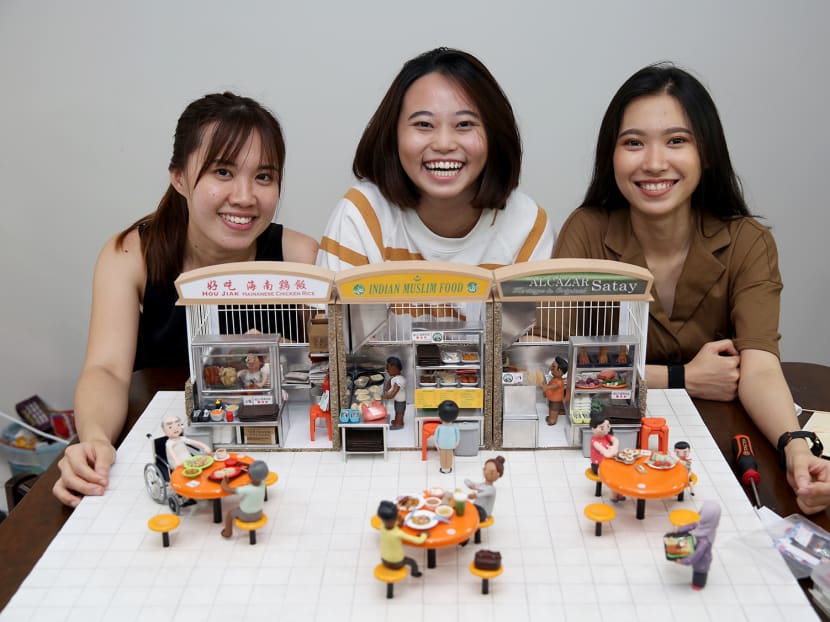 Clay artists (from left) Jocelyn Teo, 31, Oo Xin Man, 23, and Janice Ng, 20, with the miniature model of a hawker centre that they were commissioned to create by the National Heritage Board.