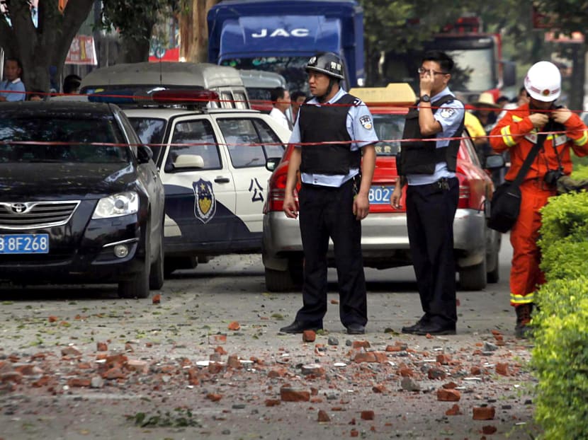 Chinese police officers stand at the scene of an explosion in Liucheng county in southern China's Guangxi Zhuang Autonomous Region on Oct 1, 2015. Photo: Chinatopix via AP