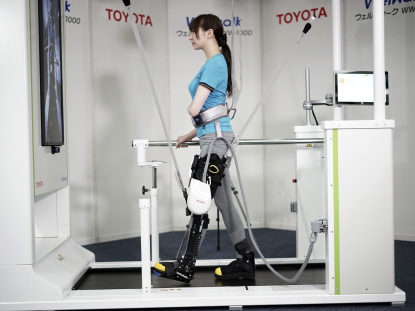 A model demonstrates the Welwalk WW-1000, a wearable robotic leg brace designed to help partially paralyzed people walk. Photo: AP