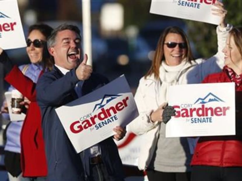 Cory Gardner, centre, Republican candidate for the US Senate seat in Colorado, joins supporters in waving placards on the corner of a major intersection in south Denver suburb of Centennial, Colorado, early on Tuesday, Nov  4, 2014. Gardner is facing Democratic incumbent Senator Mark Udall in a pitched battle for the seat. Photo: AP