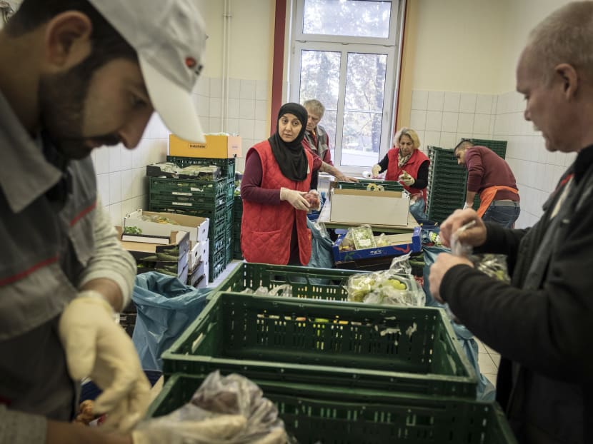 Ms Nadja Haj Mohamad, centre, sorts through delivered food at the Tafel food bank headquarters, which has seen a sevenfold increase in the number of people served since Chancellor Angela Merkel came to power, in Bremerhaven, Germany, Sept 15, 2017. Source: The New York Times