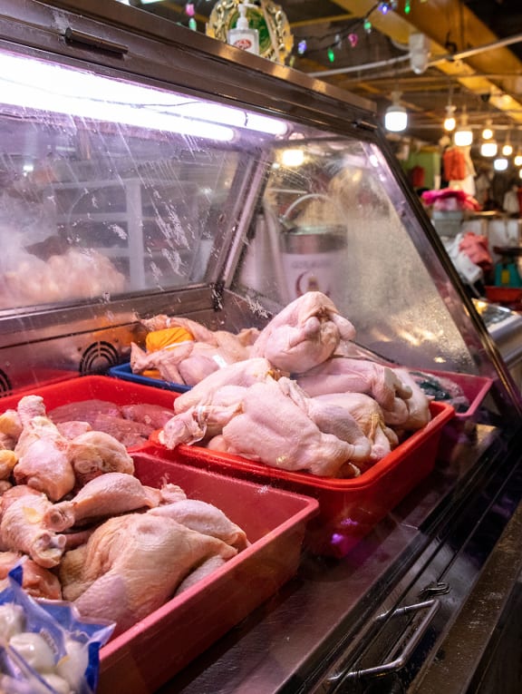 A woman walking past a poultry stall at a wet market in Yew Tee on May 25, 2022.