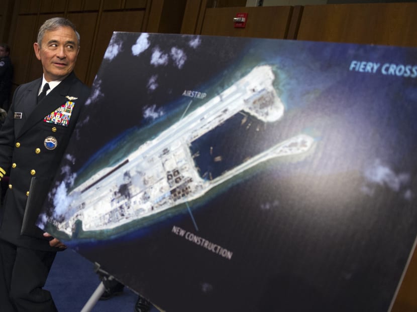Adm Harry B Harris, Jr, US Navy Commander, US Pacific Command walks past a photograph showing an island that China is building on the Fiery Cross Reef in the South China Sea. AP file photo