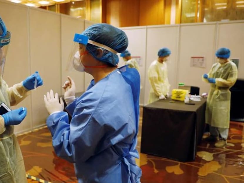 Medical workers are seen at a Covid-19 rapid antigen test center at Geo Connect Asia trade conference in Singapore on Mar 24, 2021.