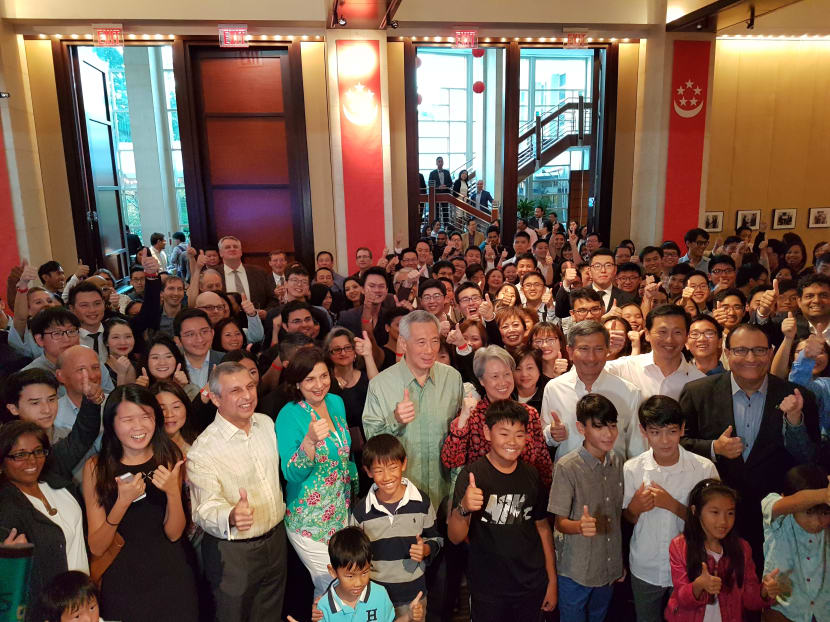 Photo of the day: Prime Minister Lee Hsien Loong and his wife Ho Ching posing for a group photo with over 200 Singaporeans at the Singapore Embassy in Washington on Oct 22, 2017. Mr Lee told them in a speech that economic growth for this year will be at the upper end of the 2 per cent to 3 per cent range. Photo: Albert Wai/TODAY