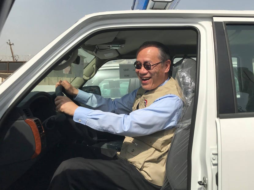 A handout picture released by the official Facebook page of the Embassy of Japan in Iraq on March 21, 2018 shows Japanese Ambassador Fumio Iwai riding in a pick-up truck during a handover ceremony of vehicles provided by Japan to the Iraqi police at an unspecified location in Iraq.