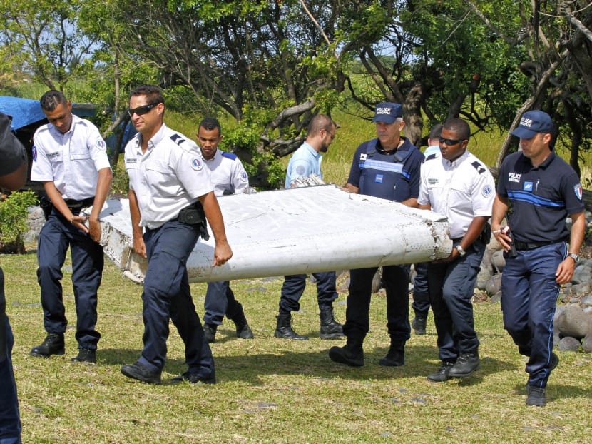 French police officers carry a piece of debris from a plane in Saint-Andre, Reunion Island. Photo: AP