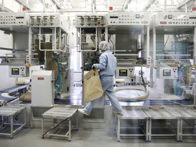 FILE PHOTO: A worker is seen through a window as he operates a machine filling wheat flour into sacks at Chiba Flour Milling Co. in Chiba east of Tokyo, November 13, 2015. REUTERS/Thomas Peter FILE PHOTO: A worker is seen through a window as he operates a machine filling wheat flour into sacks at Chiba Flour Milling Co. in Chiba east of Tokyo, November 13, 2015. REUTERS/Thomas Peter