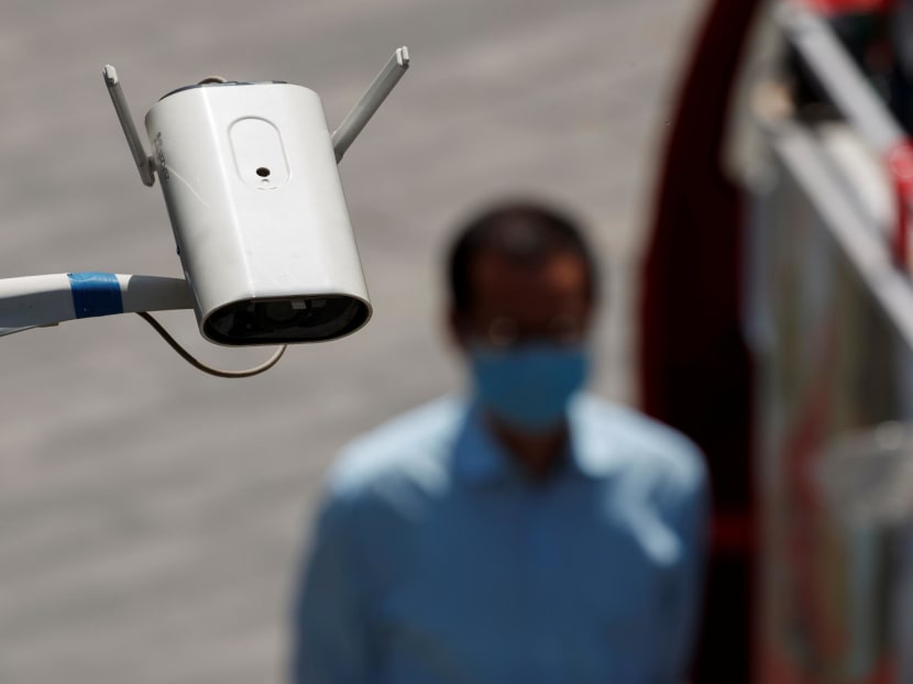 A security surveillance camera overlooks a street as a man walks past in Beijing, China on May 11, 2020.