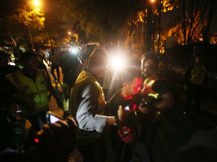 Police detain a demonstrator who failed to heed a warning to disperse near the Sri Maha Mariamman Devasthanam temple.