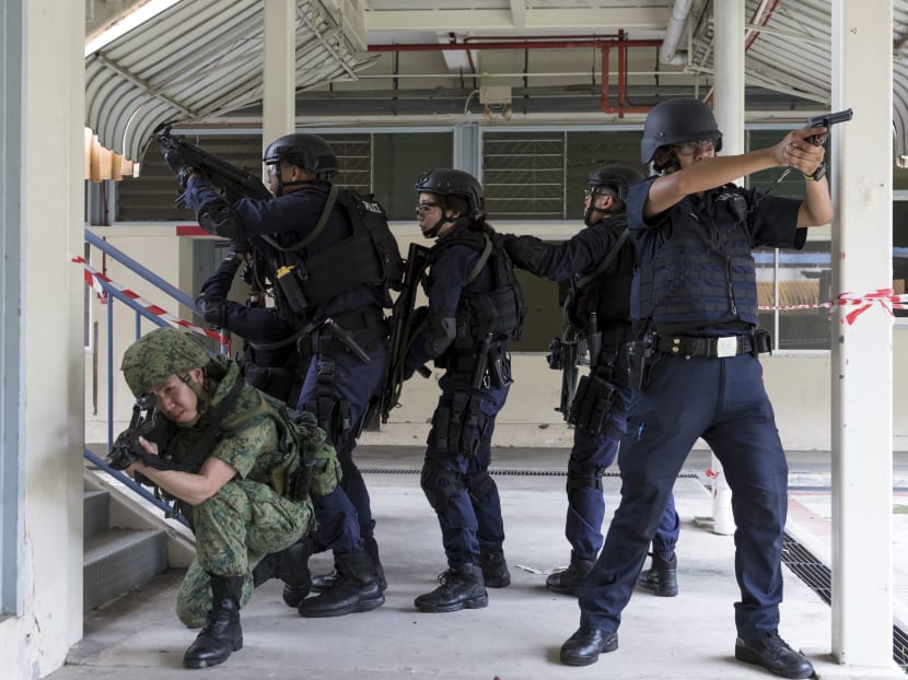 A joint training consisting of SPF and SAF personnel are seen securing an area during an active shooter simulation.