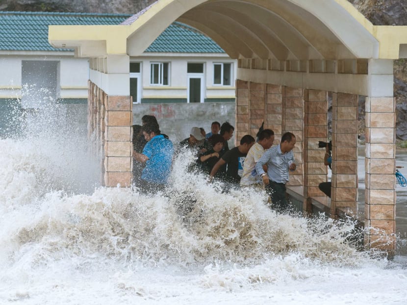 People dodge as a storm surge hits the coastline under the influence of Typhoon Fitow in Wenling, Zhejiang province. Photo: Reuters
