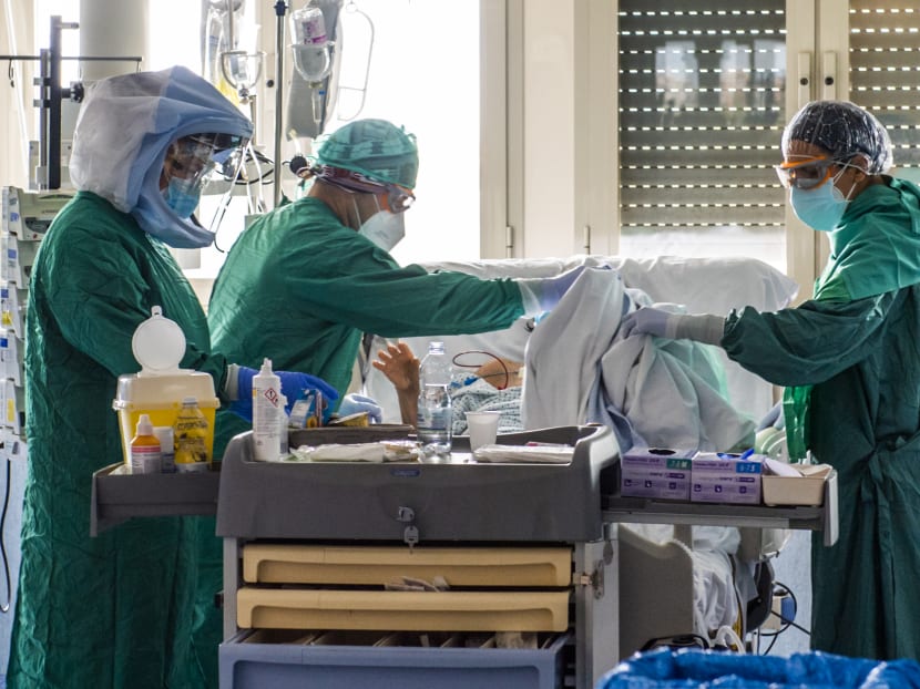 Medical workers tend to a patient at the Intensive Care Unit of the Tor Vergata Covid-4 hospital on April 21, 2020 in Rome, during the country's lockdown aimed at curbing the spread of the Covid-19 infection, caused by the novel coronavirus.
