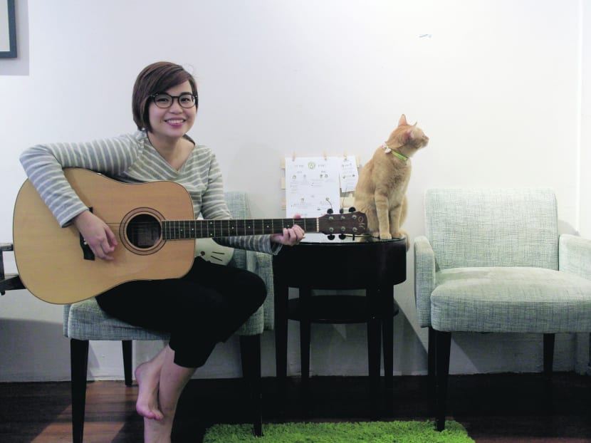 Jaime Wong (with guitar) and her furry feline fan: The musician will perform at The Company Of Cats on July 24. Photo: The Company Of Cats