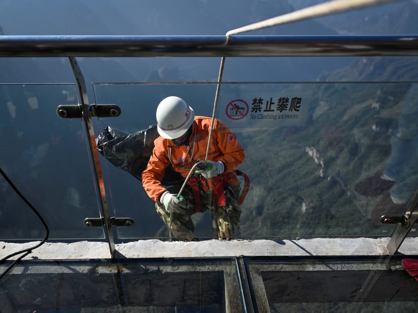 A cleaner abseils from a glass skywalk to collect litter at Tianmen mountain in Zhangjiajie, China's Hunan province on Nov 12, 2020. The team called "the Spidermen" by local media was created in 2010 to deal with waste accumulating on Tianmen mountain.