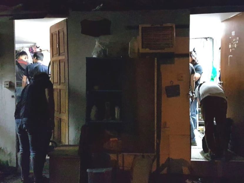 CNB officers conducting a search during one of the raids. Photo: Central Narcotics Bureau