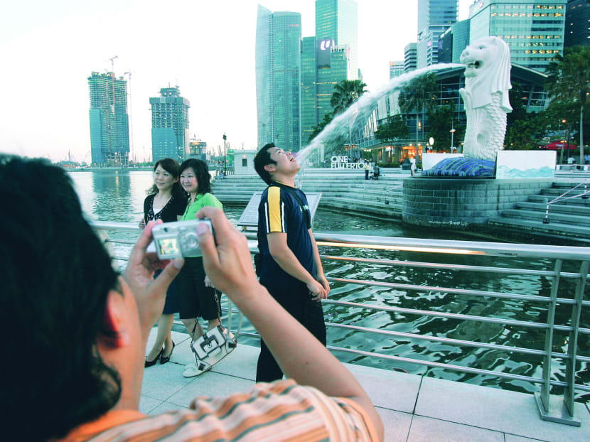 Tourists posing with the Merlion. Visitor arrivals from China could fall, due to its government curb on ‘shopping tours’. TODAY file photo