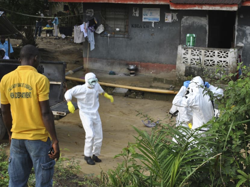 Medical staff wearing protective suits gather at a health facility near the Liberia-Sierra Leone border in western Liberia Nov 5, 2014. The World Health Organization said on Wednesday that it continued to see a slowdown in weekly Ebola cases in Liberia, although incidence of the disease was still rising in Sierra Leone and stable in Guinea. Photo: Reuters