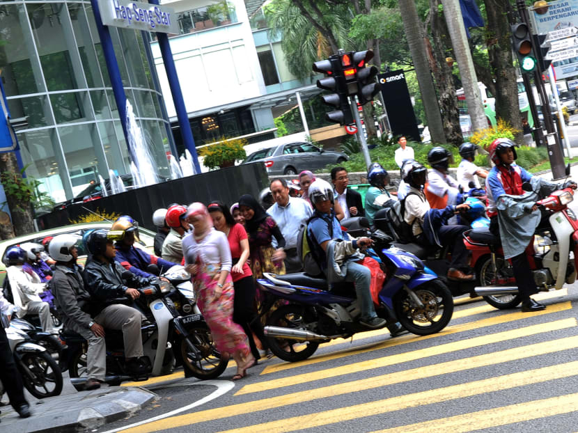 Office employees make their way through the busy hour traffic in downtown Kuala Lumpur. More young working adults in Malaysia are being declared bankrupt due to ignorance and a culture of obtaining loans. Photo: AFP