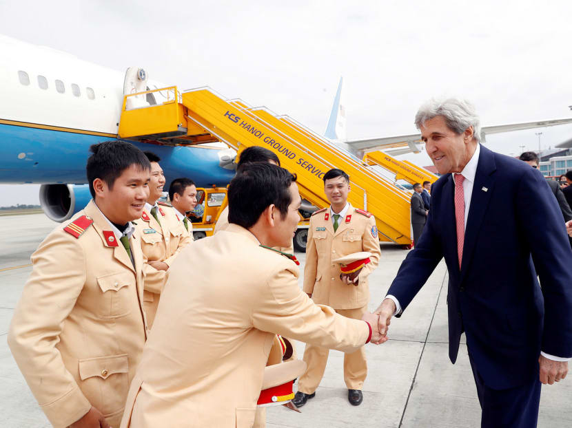 US Secretary of State John Kerry greeting police officers at Hanoi Airport yesterday before he left for Ho Chi Minh City. Today, he heads to Ca Mau province to revisit the site of his 1969 ambush. Photo: Reuters