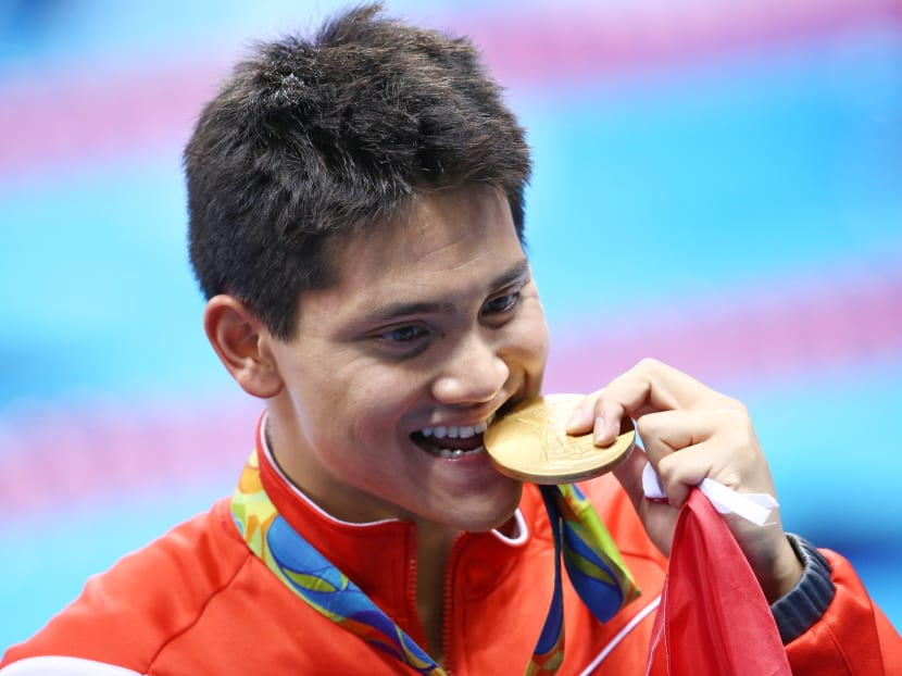 Joseph Schooling celebrates with his Olympic gold medal. Photo: Reuters