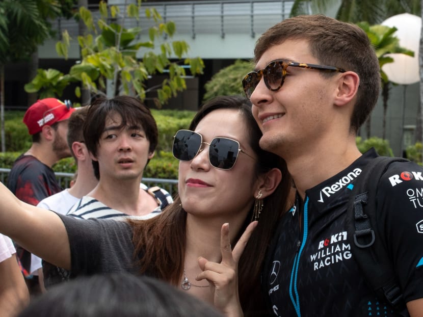 British driver George Russell (far right) posing for a photo with fans when he was in Singapore for the Formula One night race in September 2019. He is one of the hottest to-watch drivers, now racing with Mercedes in the 2022 season.