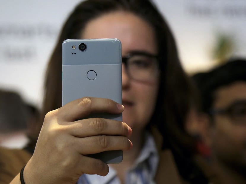 A woman looks at Google Pixel 2 phone at a Google event at the SFJAZZ Center in San Francisco. Photo: AP