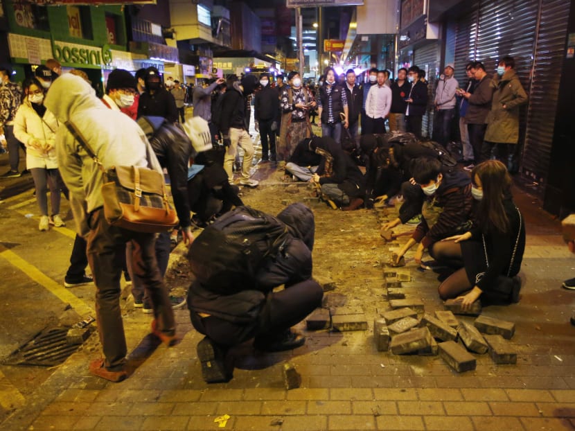Protesters collect bricks from a pathway in the Mongkok district of Hong Kong on Feb 9, 2016. Photo: AP