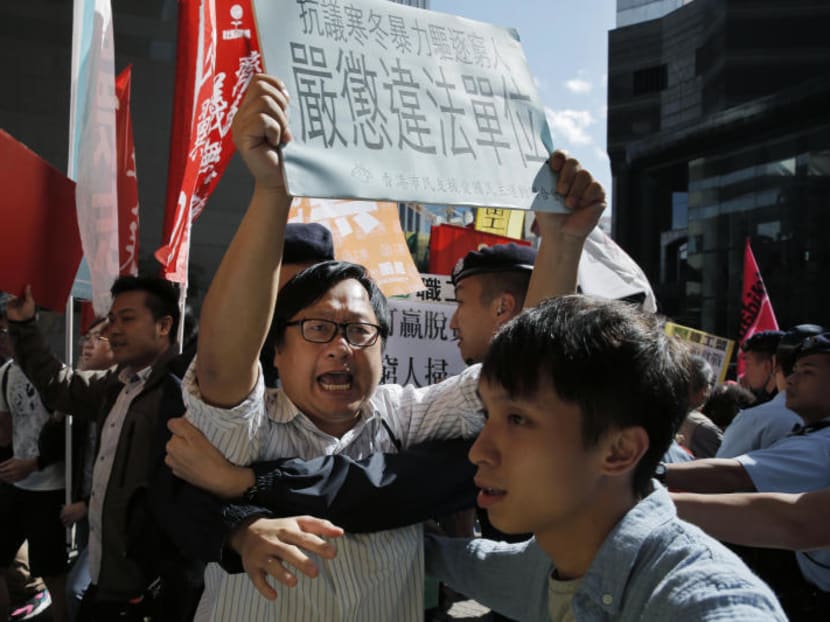 Protesters holding placards, scuffle with police officers during a demonstration in Hong Kong in November as they are against evictions of poor in Beijing. Authorities in Beijing have launched sweeping evictions of workers who have migrated from elsewhere in the country, triggering a public outcry over the treatment of people the city depends on to build skyscrapers, care for children and take on other lowly paid work. Photo: AP