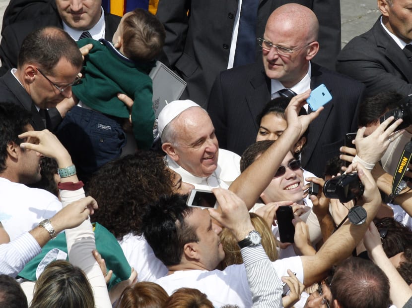 Faithful take pictures with Pope Francis at the end of the Palm Sunday Mass in St Peter's square at the Vatican, Sunday, April 13, 2014. Photo: AP