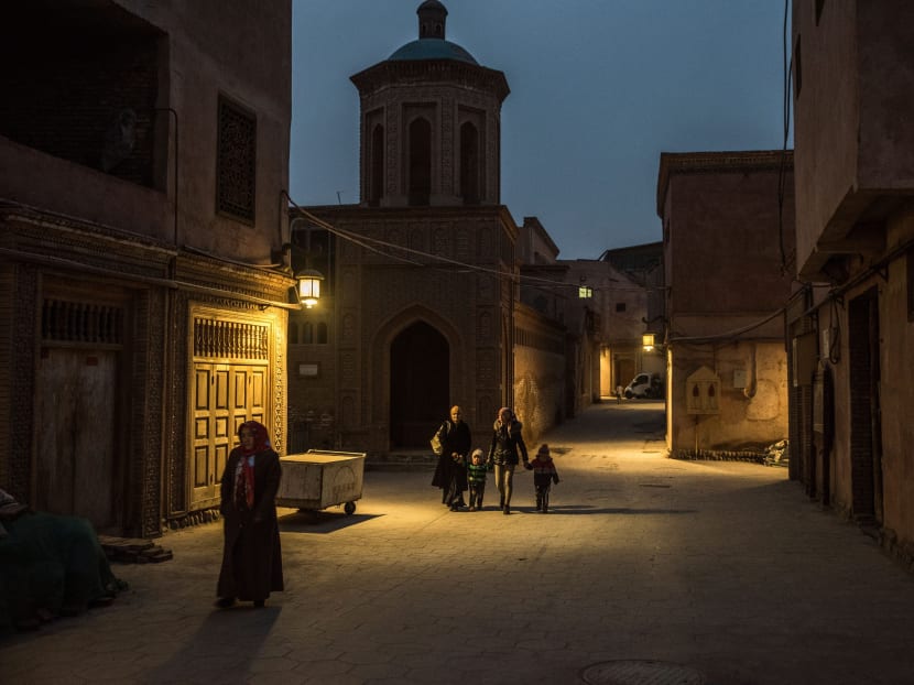 File photo of people walking past a mosque in Kashgar, a city in China's western region of Xinjiang, Dec 10, 2016. Photo: The New York Times