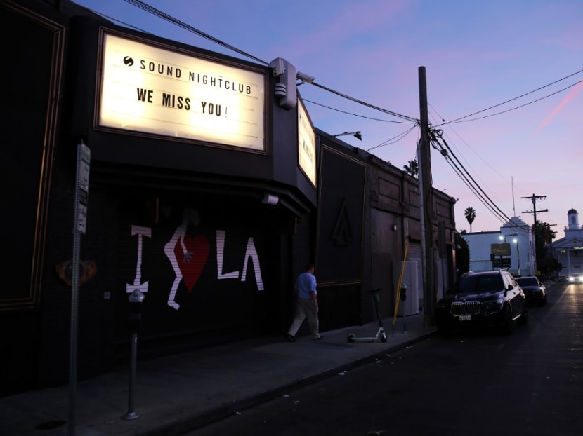 A man walks past a long-shuttered nightclub with the message "We Miss You" in Hollywood amid the Covid-19 pandemic on Dec 6, 2020 in Los Angeles, California.