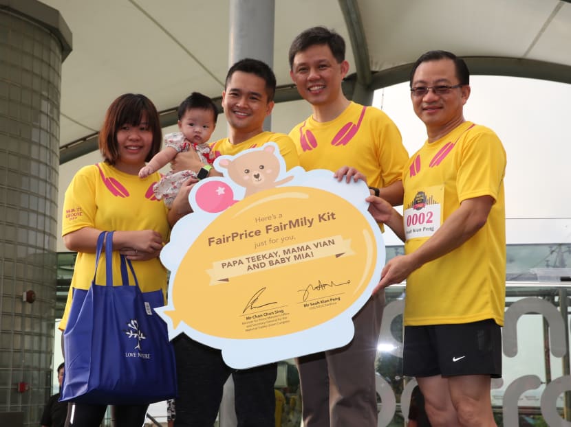 Mr He Tian Kun and Ms Vian Tee, with baby Mia, receiving the S$100 FairMily Kit on Sunday, May 21, 2017 from NTUC FairPrice CEO Seah Kian Peng and Mr Chan Chun Sing, NTUC secretary-general. Photo: Wee Teck Hian/TODAY