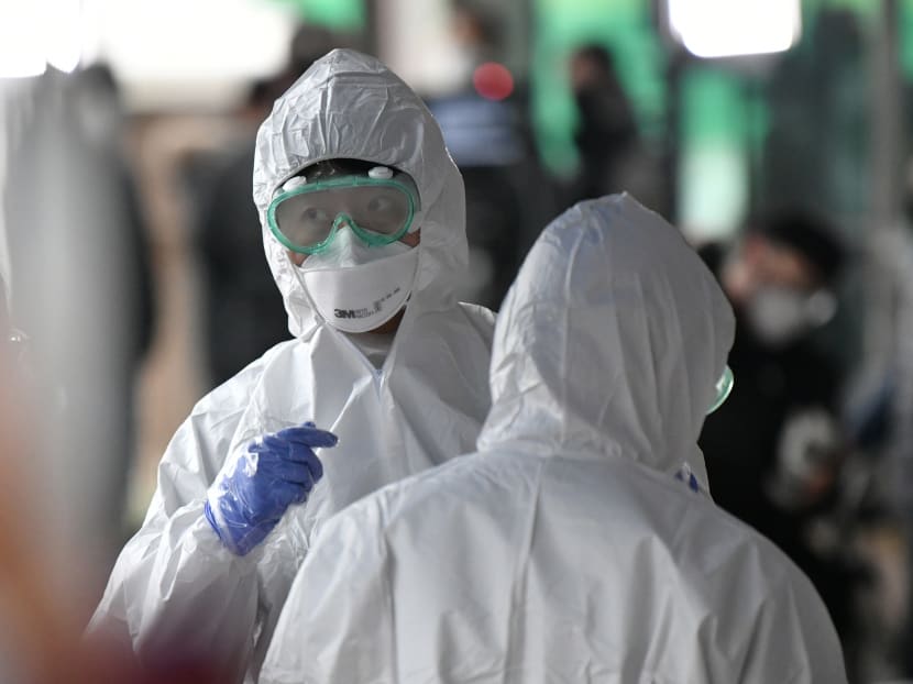 Medical staff members wearing protective gear prepare to take samples from workers at a building where 46 people were confirmed to have the Covid-19 coronavirus, at a temporary virus test facility in Seoul on March 10, 2020.