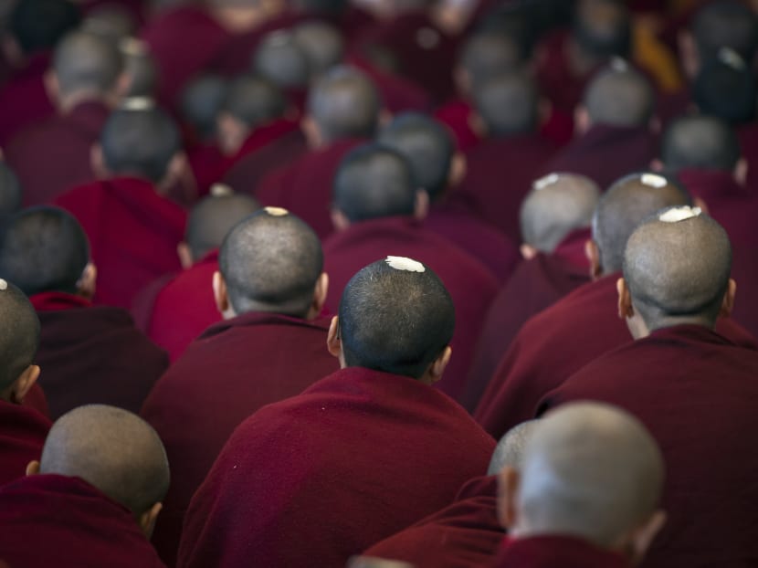 Ceremonial seeds seen on the shaven heads of exiled Tibetan Buddhist monks as they listen to a religious talk by the Dalai Lama at the Tsuglakhang temple in Dharmsala, India, on March 14, 2017. Photo: AP