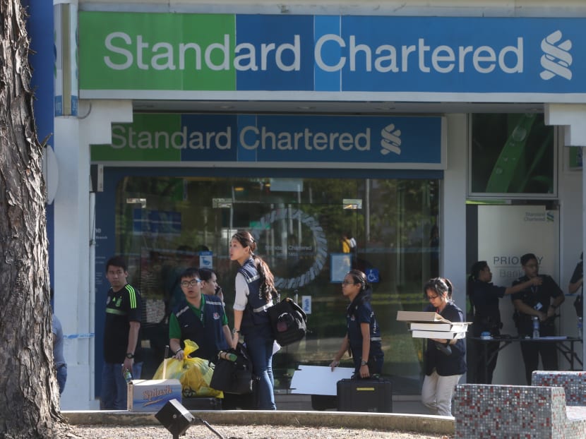 CID officers packing up outside the Standard Chartered bank branch at Holland Village after a robbery occurred on July 7. Photo: Ooi Boon Keong