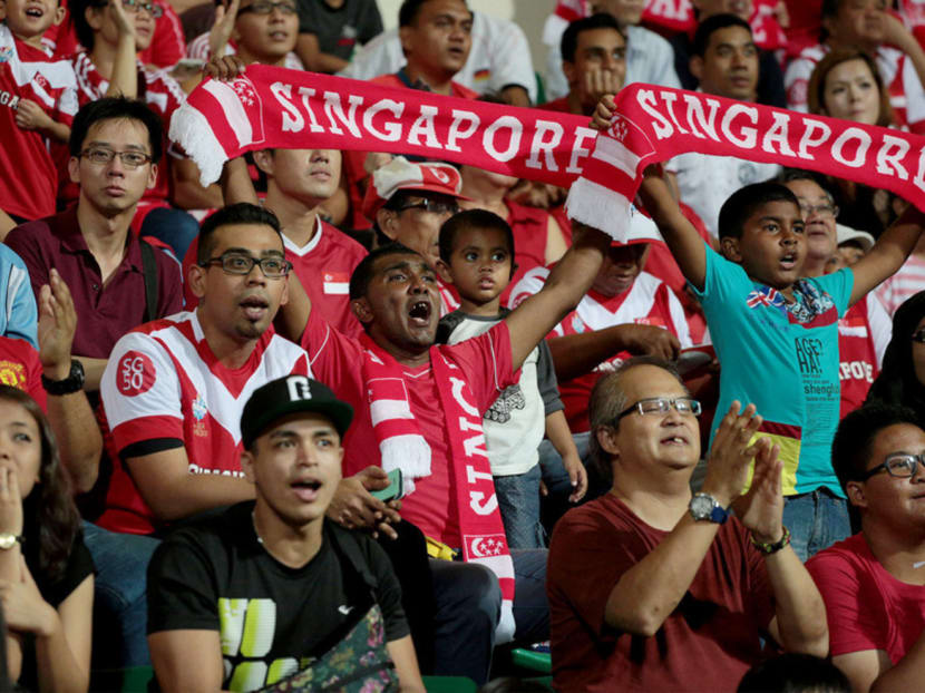Singapore fans cheering during the match against Cambodia. The Young Lions need to beat Indonesia in their match tonight to reach the semi-finals. Photo: Jason Quah