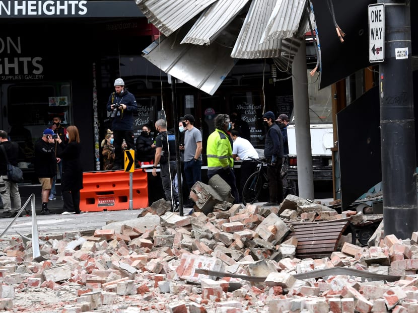 People gather near a damaged building in the popular shopping Chapel Street in Melbourne on Sept 22, 2021, after an earthquake.