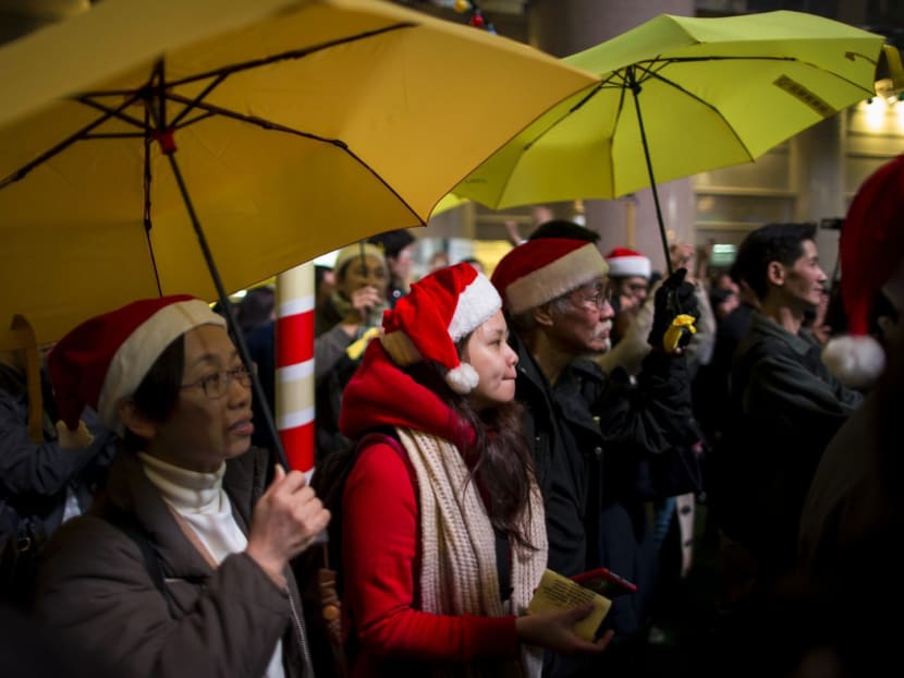 Pro-democracy protesters, holding up yellow umbrellas, a symbol of the Occupy Central civil disobedience movement, attend a protest at Times Square in Hong Kong early December 25, 2014. Photo: Reuters
