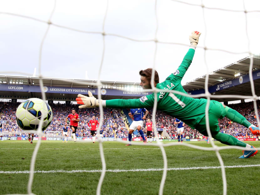 David de Gea of Manchester United diving in vain as Leonardo Ulloa (obscured) of Leicester City scores his team’s fifth goal from the penalty spot during Sunday’s match. Leicester unexpectedly came from 3-1 down to beat United 5-3. 
Photo: Getty Images