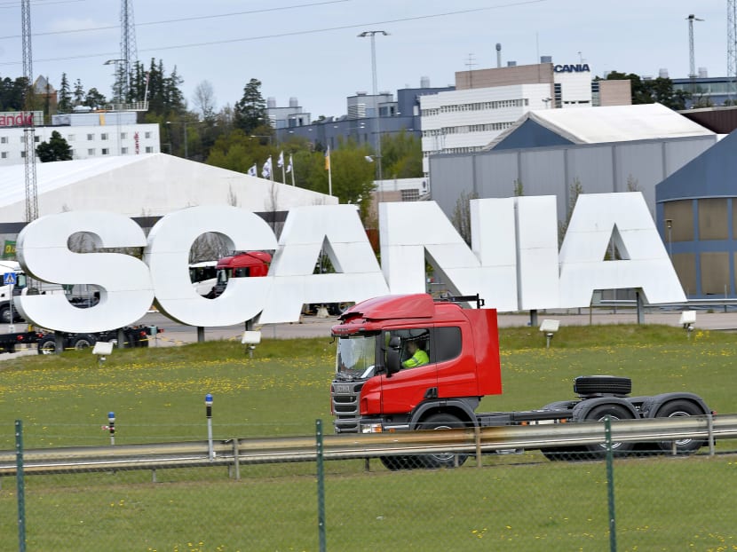 A Scania truck moves past a giant company logo outside the Swedish truck-maker's plant in Sodertalje, Sweden. As the economy becomes more information-intensive — even heavy industries such as oil and gas are becoming data-driven — the cost of blocking those flows of information increases.