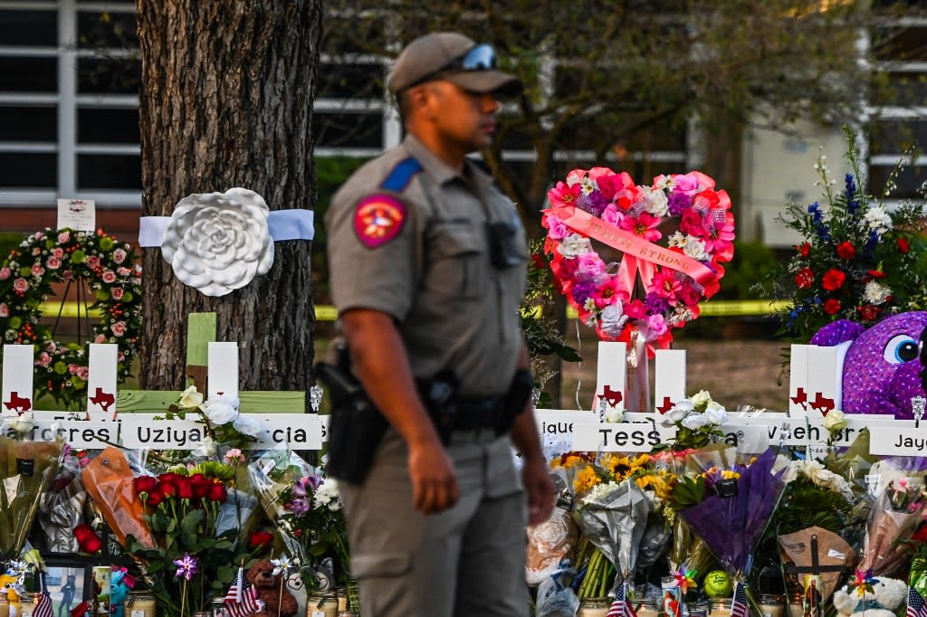 In this file photo taken on May 27, 2022, a police officer stands near a makeshift memorial for the shooting victims outside Robb Elementary School in Uvalde, Texas. In this file photo taken on May 27, 2022, a police officer stands near a makeshift memorial for the shooting victims outside Robb Elementary School in Uvalde, Texas. 