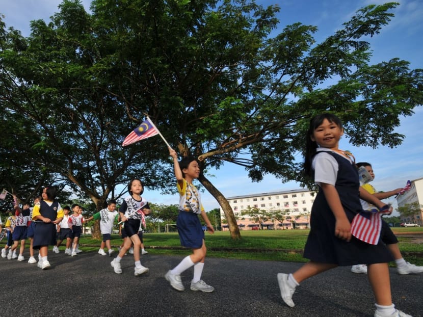 School children in Malaysia waving the national flag. In Malaysia national schools give lessons in Malay and English, and vernacular schools teach in Mandarin and Tamil. Photo: South China Morning Post