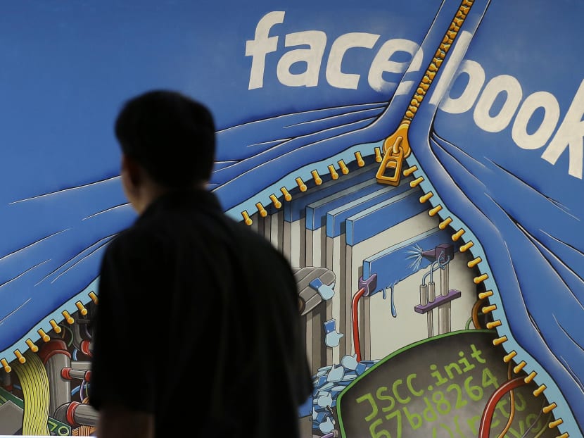 A man walks past a mural in an office on the Facebook campus in Menlo Park, Calif. AP file photo