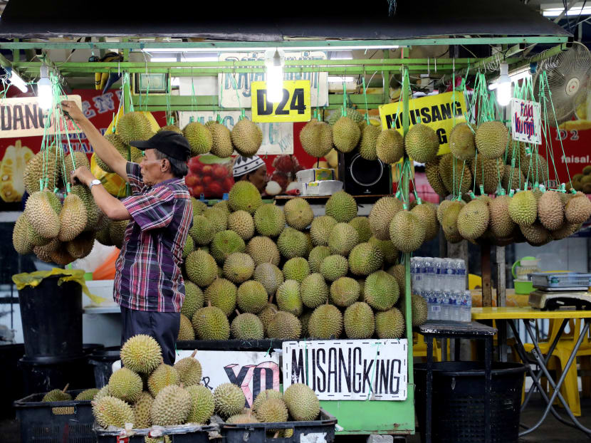 A man arranges durians at a market stall in Kuala Lumpur, Malaysia.