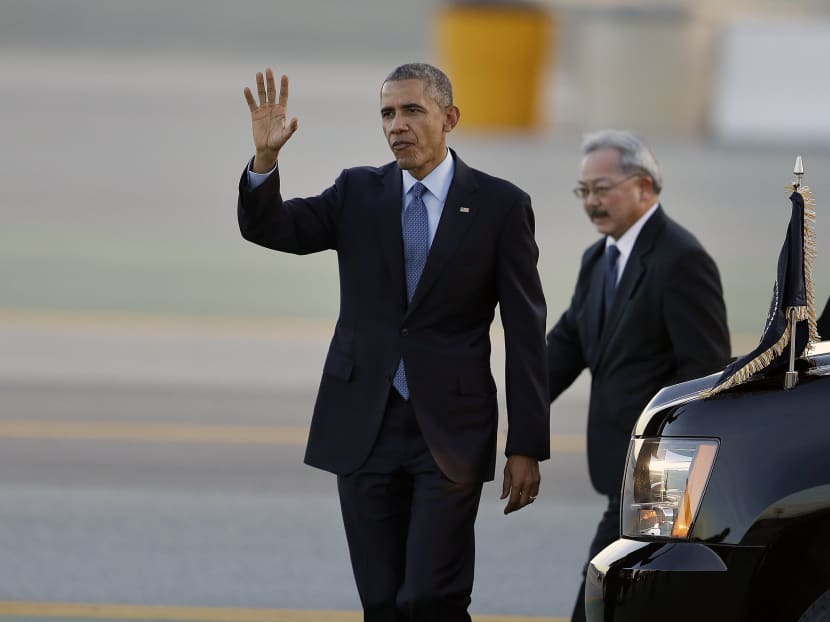 President Barack Obama, left, waves upon his arrival at San Francisco International Airport with San Francisco Mayor Ed Lee, right, Feb 12, 2015 in San Francisco. Photo: AP