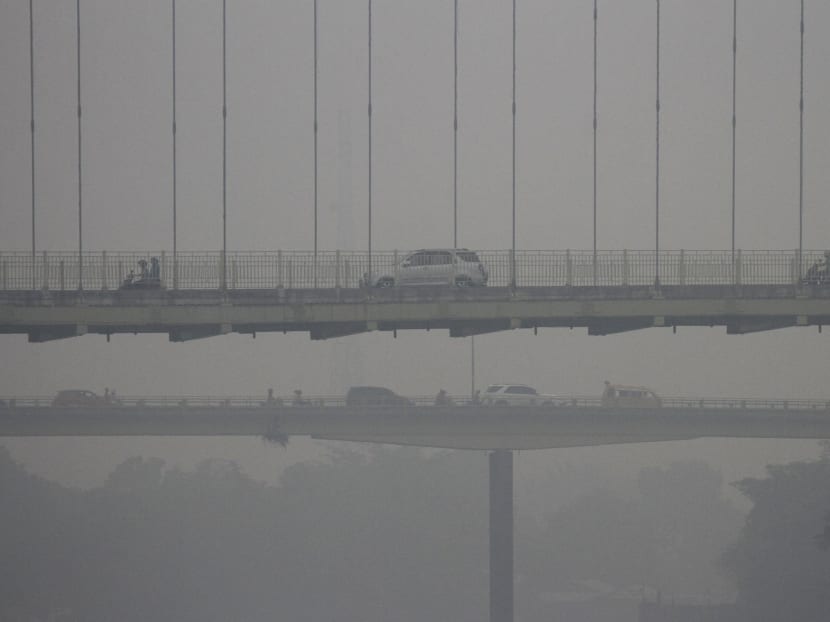 Vehicles drive along Siak Bridge, shrouded by haze, in Pekanbaru, Indonesia's Riau province on Oct 11, 2015. Photo: Reuters