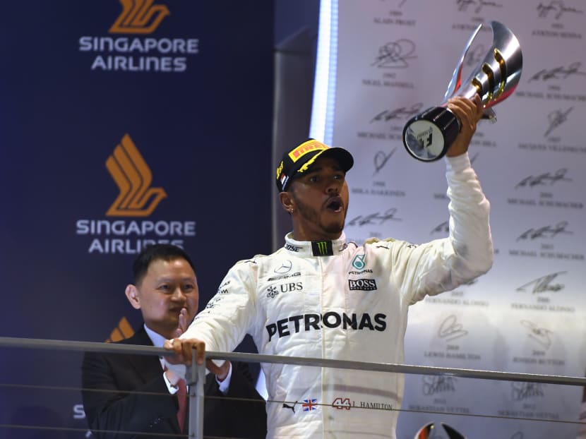 Lewis Hamilton celebrates after he takes the chequered flag (and the trophy) at the Singapore Grand Prix on Sunday, Sept 17, 2017. Photo: AFP